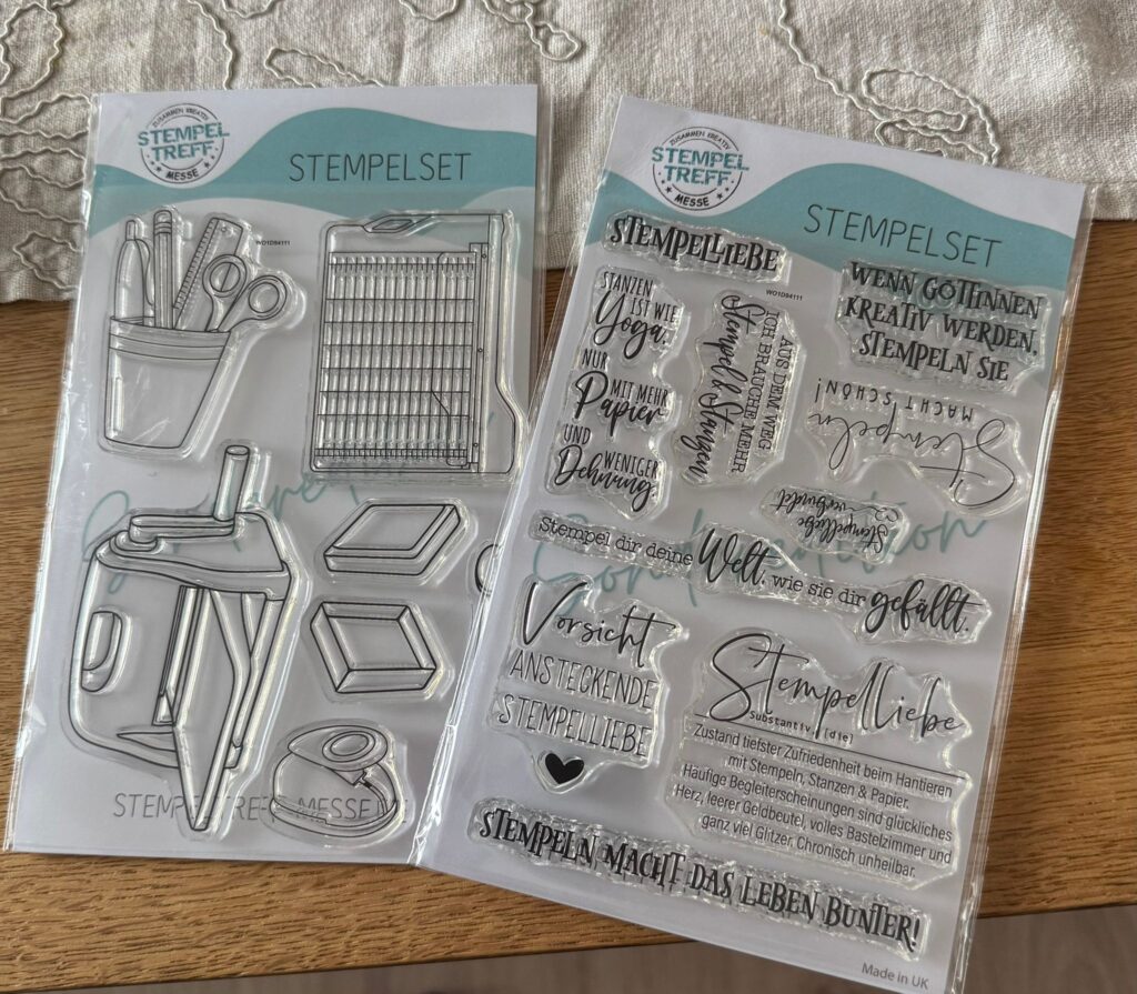 Stempelset mit verschiedenen transparenten Stempeln fĂĽr kreative Bastelprojekte, einschlieĂźlich Werkzeugen, Texten und Ornamente, auf einem Holzuntergrund.